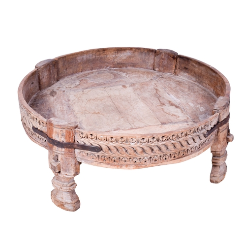 177 - A circular wooden coffee table. Having carved decoration to the exterior, raised on shaped supports,... 