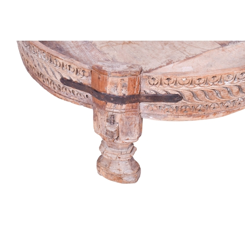 177 - A circular wooden coffee table. Having carved decoration to the exterior, raised on shaped supports,... 