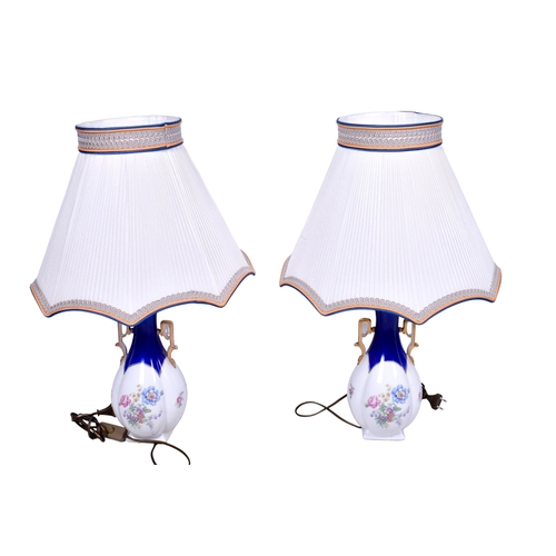 186 - A pair of Limoges ceramic lamp bases with shades. Both of baluster form, glazed in white with blue a... 