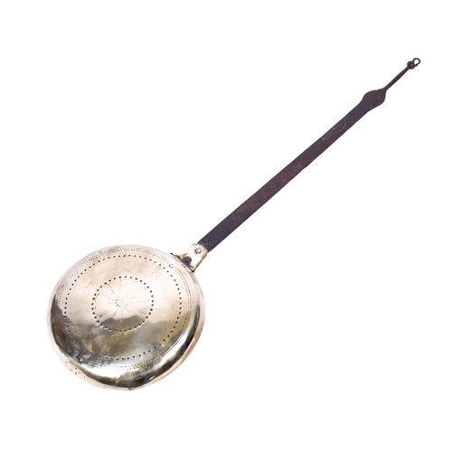 192 - A vintage bed warmer. Having a metal handle and brass cover with impressed decoration, L97.5cm.