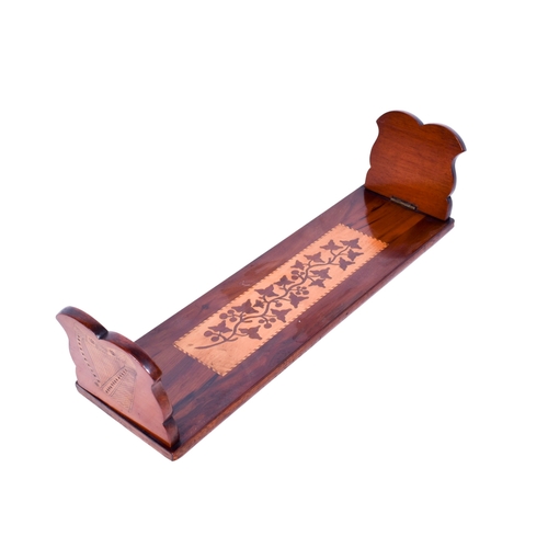 223 - A mahogany marquetry book trough, possibly Irish. Having folding ends with harp engraved decoration ... 