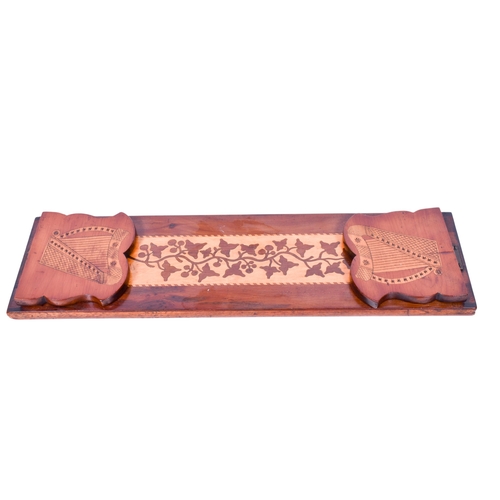223 - A mahogany marquetry book trough, possibly Irish. Having folding ends with harp engraved decoration ... 