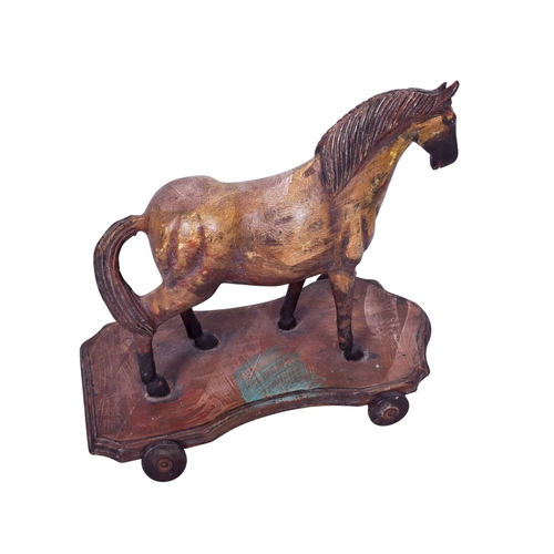 245 - A vintage pull-along wooden model of a horse. Painted and mounted on a shaped base fitted with wheel... 