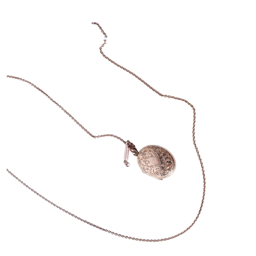 35 - A 9ct gold locket and chain. The oval locket with engraved scroll decoration and blank central paper... 