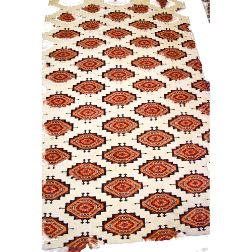 521 - A large Turkamen style wool rug on a red ground. Having multiple geometric borders with a Gul motif ... 