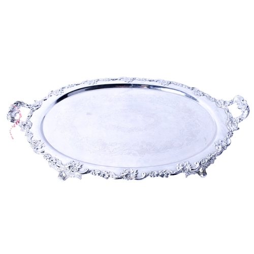 91 - A silverplated twin-handled tray. Of oval form, with a moulded floral border and etched decoration, ... 