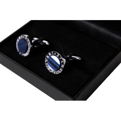 64 - A pair of Bulgari white metal and cufflinks. Inset with blue panels encircled by the company name, d... 