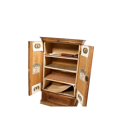 554 - A vintage wooden cigar cabinet. The panelled doors opening to reveal three shelves over a single dra... 