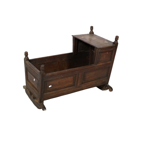 456 - A vintage oak baby crib. The tapered panelled sides topped with turned finials, raised on rockers, H... 
