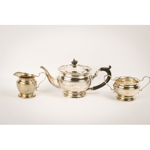 10 - An early 20th century silver teapot, sugar bowl and cream jug set. With fluted rim over a ribbed bod... 