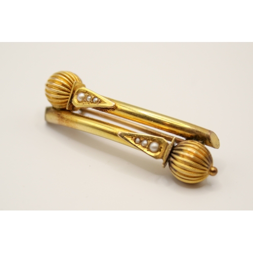 154 - A 19th century yellow metal Etruscan style bar brooch. Of double baton form with textured details, u... 