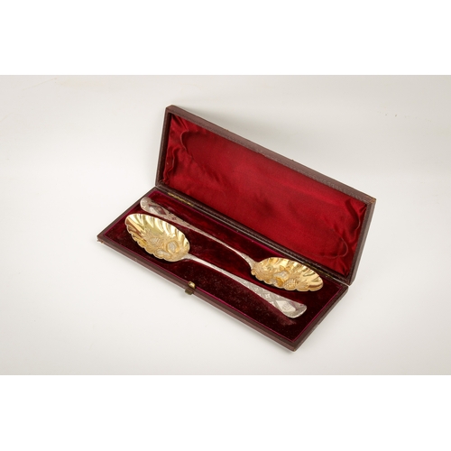 44 - A pair of George III silver berry spoons. The gilt bowls with repoussé decoration of a pineapple and... 