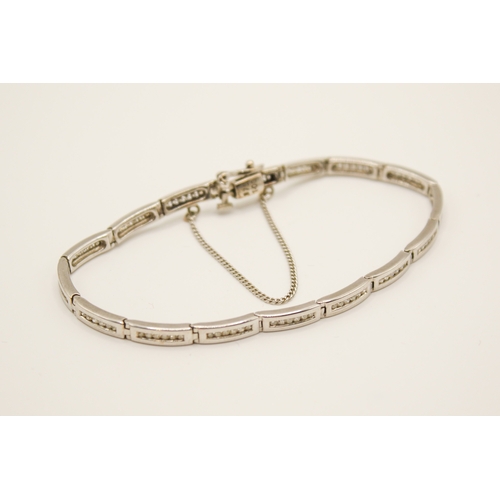 192 - A 9ct white gold and diamond bracelet. The sixteen narrow panels each channel set with six small rou... 