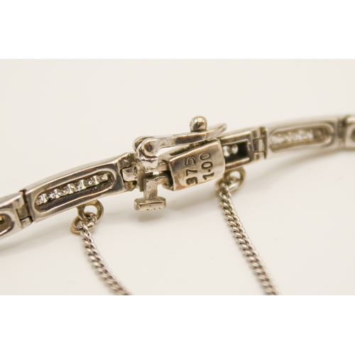192 - A 9ct white gold and diamond bracelet. The sixteen narrow panels each channel set with six small rou... 