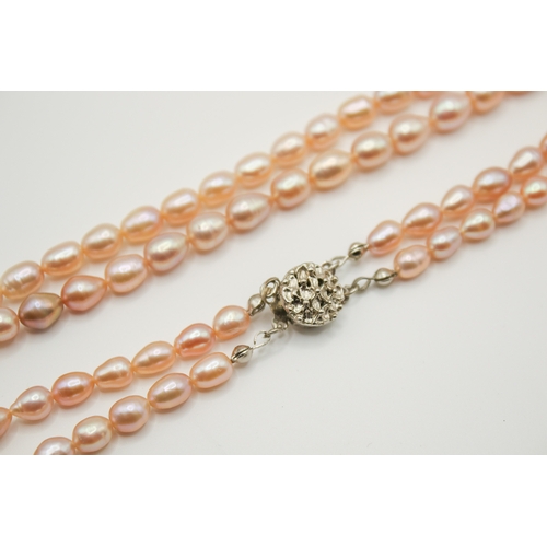 170a - A double strand of pale pink freshwater pearls. Of variegated tone and shape, each bead circa 8mm lo... 
