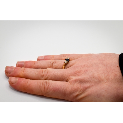102 - A hallmarked 18ct gold three stone ring. Set with one oval faceted sapphire of 0.48 carats estimated... 