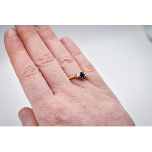 102 - A hallmarked 18ct gold three stone ring. Set with one oval faceted sapphire of 0.48 carats estimated... 