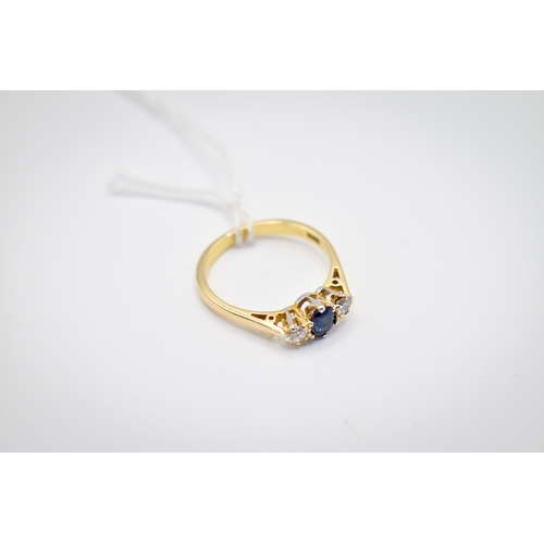 102 - A hallmarked 18ct gold three stone ring. Set with one oval faceted sapphire of 0.48 carats estimated... 