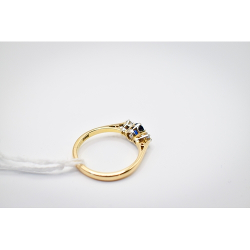 102 - A hallmarked 18ct gold three stone ring. Set with one oval faceted sapphire of 0.48 carats estimated... 
