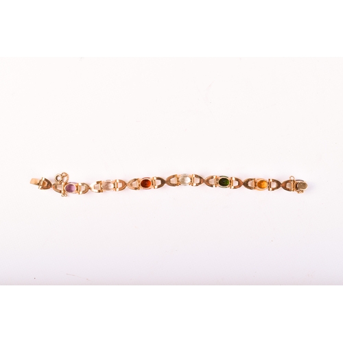 177 - A yellow metal stone set bracelet. Set with various oval cut stones in a cross link setting, includi... 
