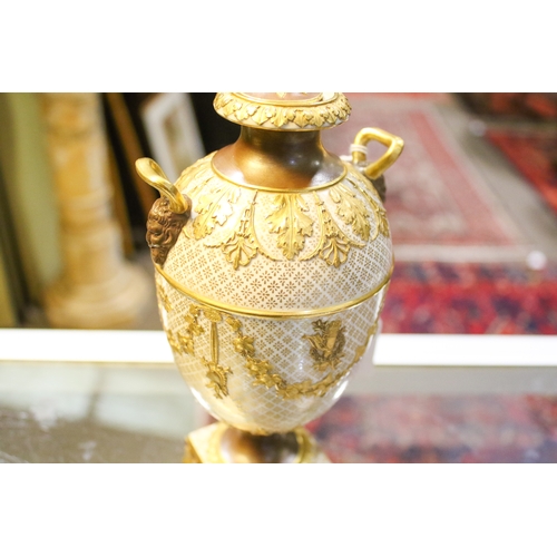 149 - A late 19th/early 20th century Wedgwood gilt urn and cover. With Bacchus head and horn handles, deco... 