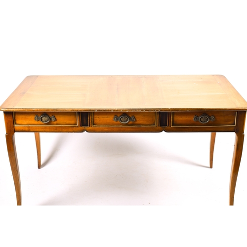 305 - A 20th century French writing table. Three frieze drawers, blind drawers to the rear. Raised on squa... 