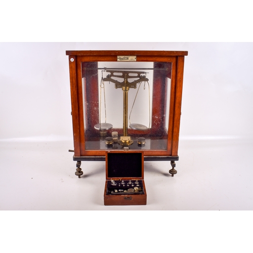 162 - A mid-century set of scales by Dertling. Contained within a glazed mahogany cabinet raised on metal ... 