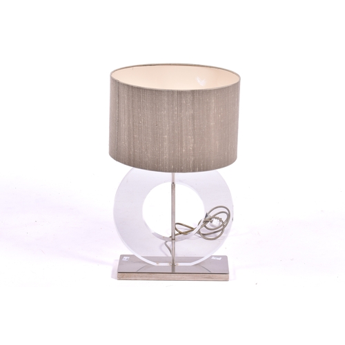 25 - A contemporary Porta Romana clear perspex table lamp. Raised on a rectangular metal base. H34cm