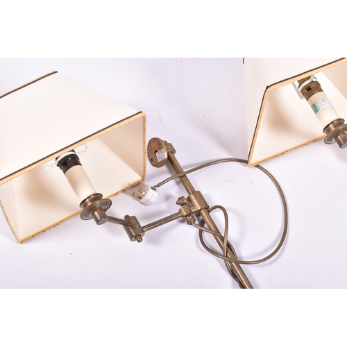 27 - A pair of antique brass effect swing arm wall lights. H52cm
