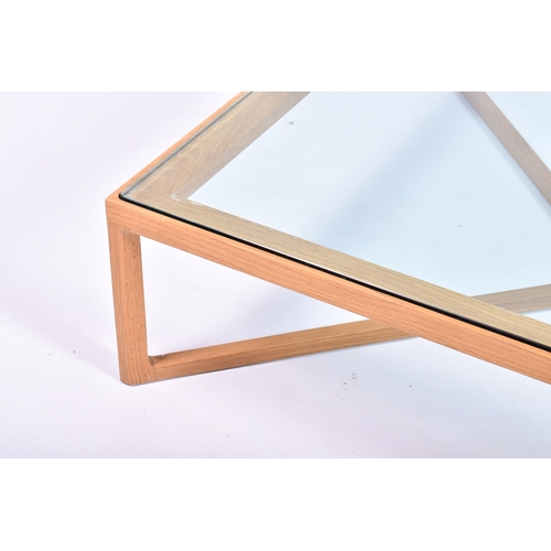 30 - A Knoll 'Krusin' light oak coffee table with thick, clear glass top, retailed by Heals. Square bevel... 