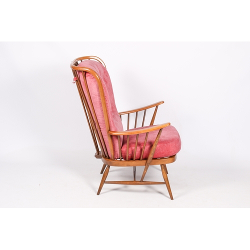 57 - A mid-century, Ercol 'Evergreen' armchair. Beech frame with spindle back and arm rests, pink/red uph... 