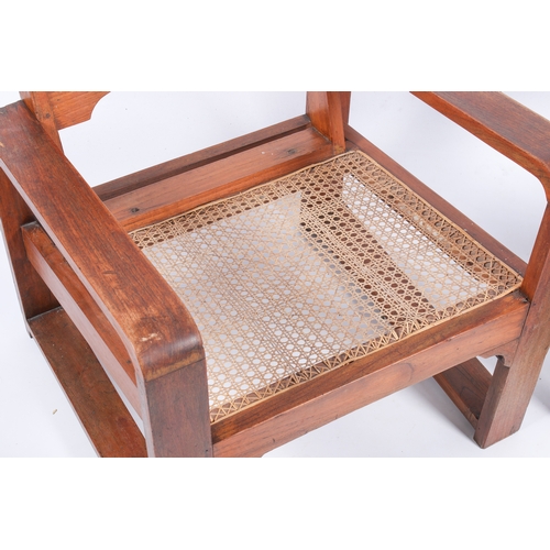 9 - A pair of 20th century Art Deco style teak armchairs. Shaped arms and backrest with wave edge and ca... 