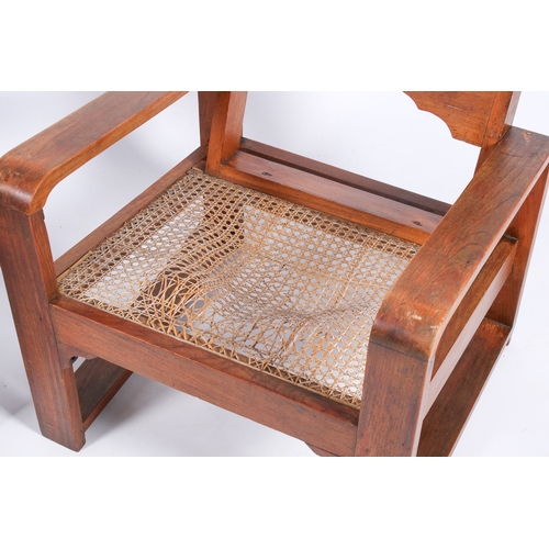 9 - A pair of 20th century Art Deco style teak armchairs. Shaped arms and backrest with wave edge and ca... 