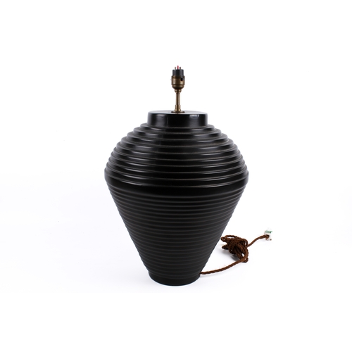202 - A contemporary black ceramic table lamp of ribbed baluster form. H39cm