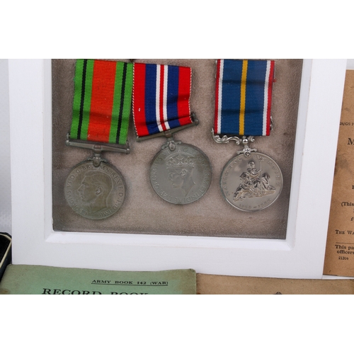 34 - A WWII medal and booklet group. Comprising two unmarked medals and a National Service medal with rib... 