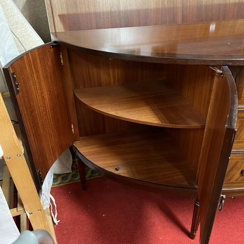 69 - Bow fronted flamed mahogany sideboard with double cupboard ends and triple drawer centre on turn leg... 