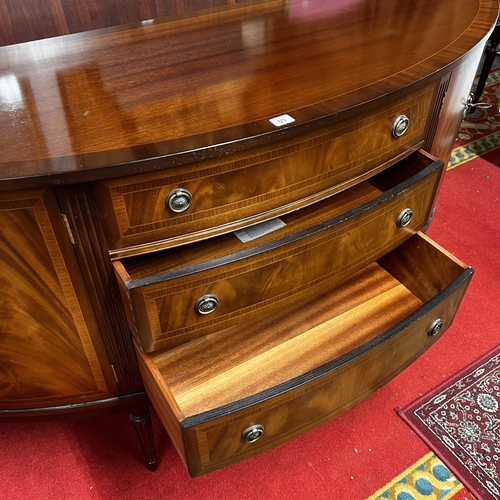 69 - Bow fronted flamed mahogany sideboard with double cupboard ends and triple drawer centre on turn leg... 