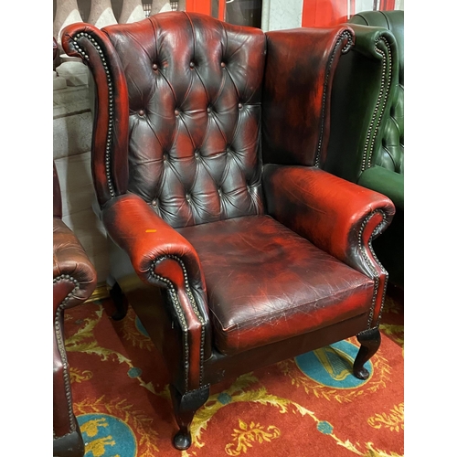 32 - Oxblood red Chesterfield leather winged back armchair on Queen Anne legs