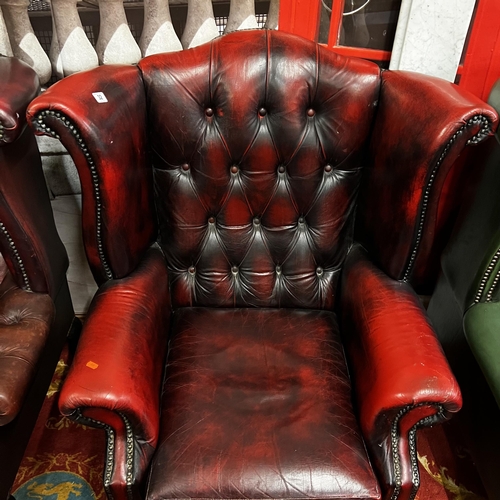 32 - Oxblood red Chesterfield leather winged back armchair on Queen Anne legs