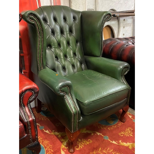 33 - Green leather Chesterfield winged back armchair on Queen Anne legs