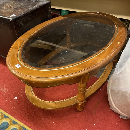 61 - Oval bevelled glass top coffee table with gold trim