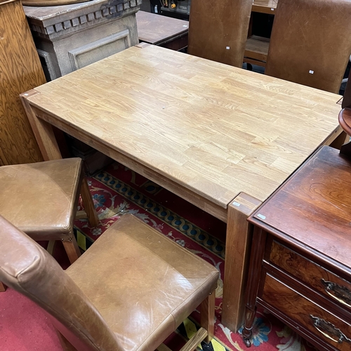 1 - Golden oak dining table with four brown leather chairs