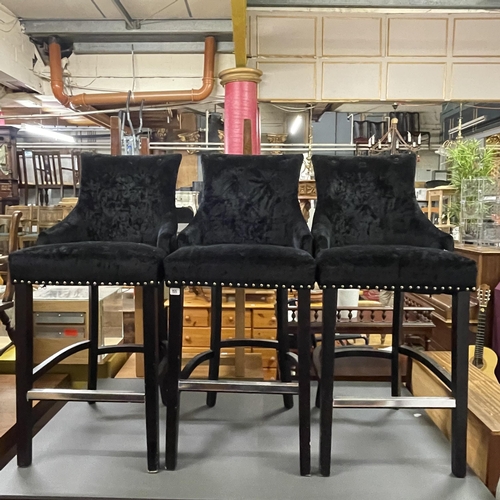 155 - SET OF THREE BLACK VELOUR HIGH BARSTOOLS WITH CHROME STUDS AND FOOT RAILS AND CHROME HANDLES ON THE ... 