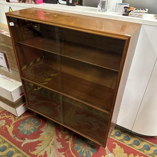 124 - VINTAGE TEAK DOUBLE SLIDING GLASS DOOR BOOKCASE ON TAPERED LEG