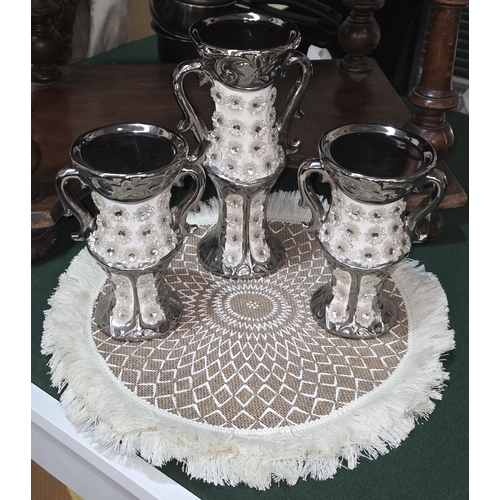135 - THREE SILVER LUSTRE CANDLE STICKS ON WOVEN MAT