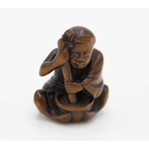 177 - Title: Wood netsuke of a seated man pounding mochi
Date: 19th century
Size: approx. (H) 3.7 x (W) 3.... 