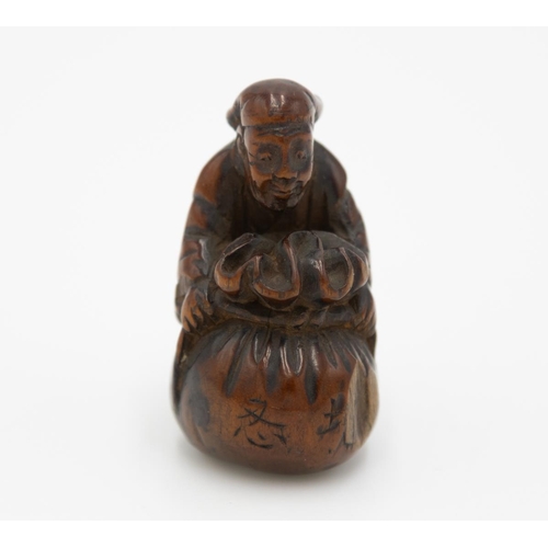 178 - Title: Wood netsuke of a merchant with a sack
Date: 19th century
Size: approx. (H) 4.3 x (W) 2.5 x (... 