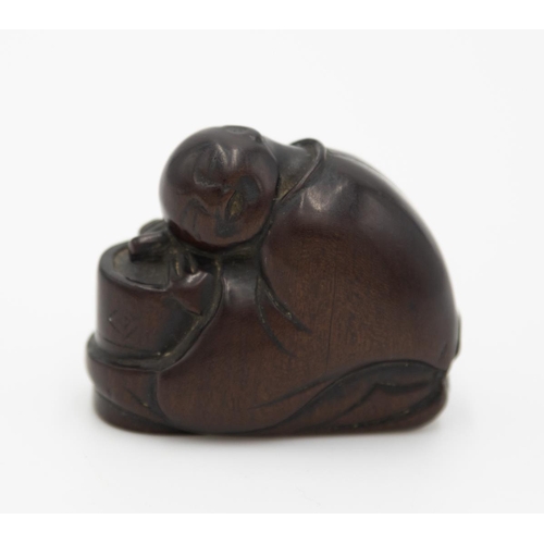 180 - Title: Wood netsuke of a monk resting his head on a cha-usu (tea grinder)
Date: 19th century
Size: a... 