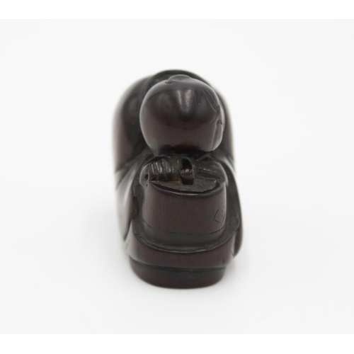 180 - Title: Wood netsuke of a monk resting his head on a cha-usu (tea grinder)
Date: 19th century
Size: a... 