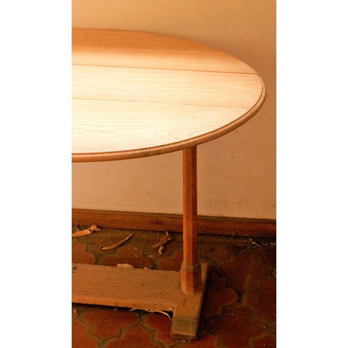 13 - Oak drop flap table in the manner of the Cotswold School, oval top on octagonal chamfered supports, ... 